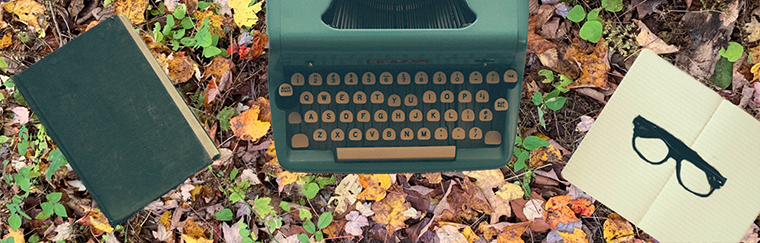 book, typewriter, notebook with leaves on the backgroud